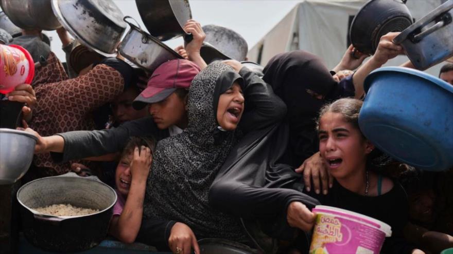 Niños palestinos esperando recibir comida de un centro de distribución en Jan Yunis, en la Franja de Gaza, 21 de abril de 2025.