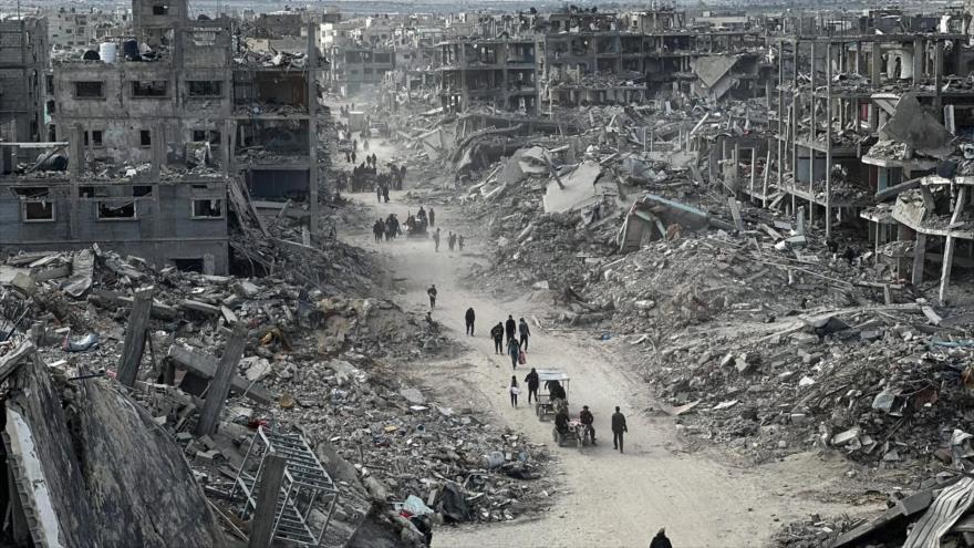 Los palestinos caminan entre los escombros causados por los ataques israelíes en la Franja de Gaza.