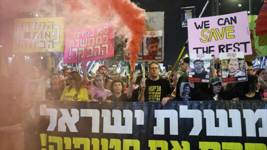 Colonos israelíes portan carteles de retenidos durante una protesta antigubernamental pidiendo el fin de la guerra en Gaza.