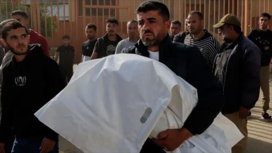 Un hombre sostiene el cuerpo envuelto de un niño palestino muerto en un ataque israelí en el Hospital Nasser, en Jan Yunis, en el sur de la Franja de Gaza, el 11 de mayo de 2025. (Reuters)