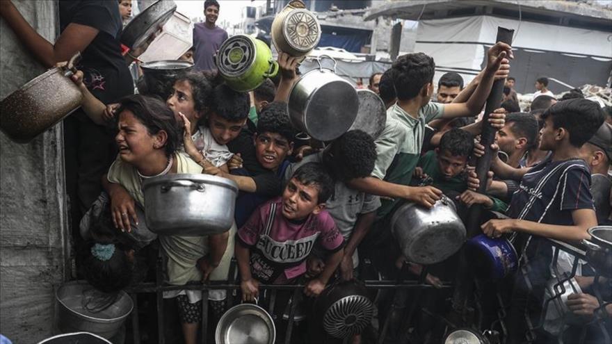 Niños palestinos hambrientos, aglutinados para intentar conseguir algo de comida.