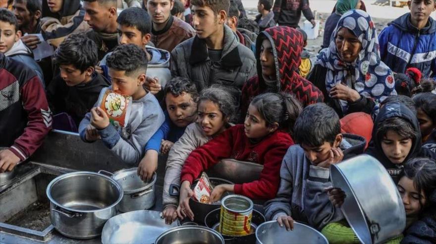 Palestinos con cuencos vacíos esperan comida en un punto de donación en Rafah. (Foto: Getty Images) 
