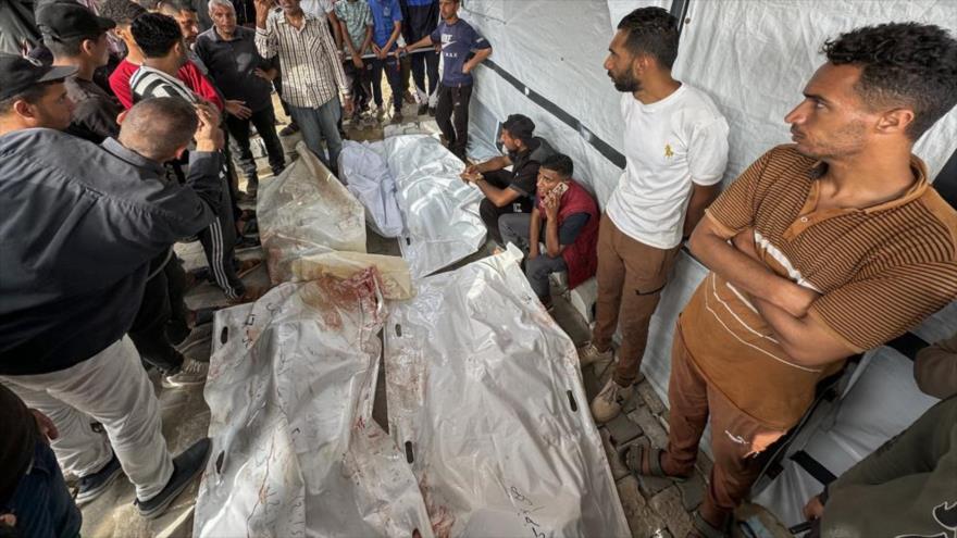 Palestinos junto a los cuerpos de sus familiares asesinados por los ataques israelíes, en el hospital Nasser de Jan Yunis. (Foto: AFP)
