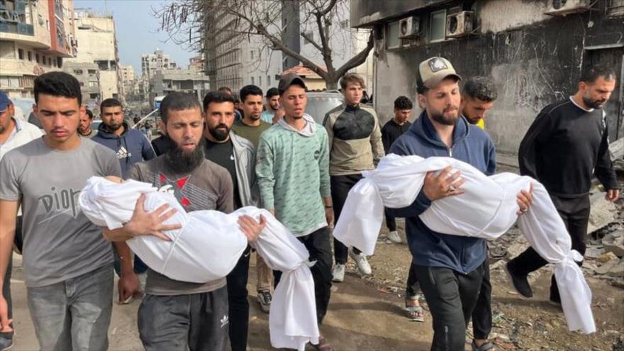 Palestinos cargan los cadáveres de niños muertos en un ataque israelí contra una escuela convertida en refugio, Gaza, 23 de abril. (Foto: X)