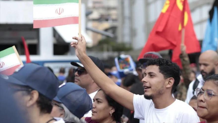 Participantes en la Gran Marcha por la Paz en Caracas hondean banderas de Irán, 25 de junio de 2025.