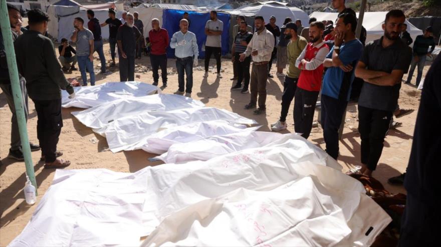 La gente rodea cuerpos de sus seres queridos asesinados en ataques israelíes en un hospital de Beit Lahia, en el norte de Gaza, mayo de 2025.
