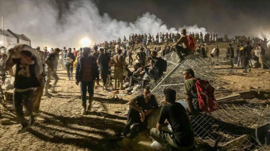 Palestinos en un acceso cercado lleva a un punto de ayuda con comida custodiado por tropas israelíes y mercenarios, 29 de junio de 2025.

