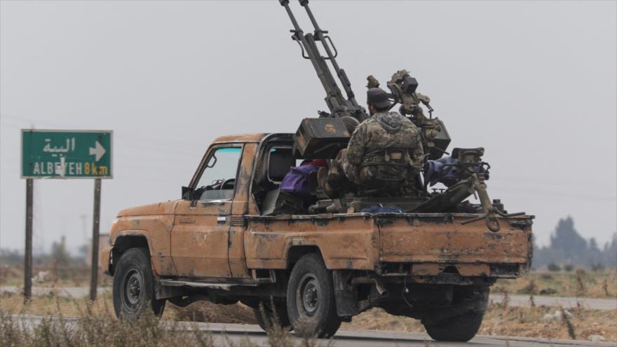 Fuerzas militares sirias a bordo de un vehículo en una zona rural de Homs.