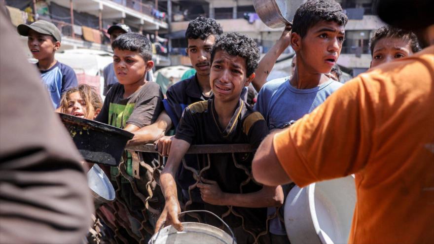Niños hacen fila con ollas para recibir comida de un comedor social en la ciudad de Gaza, 14 de julio de 2025. (Foto: AFP)