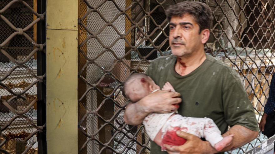 Un iraní lleva un bebé después de los ataques israelíes contra civiles, mediados de junio de 2025.
