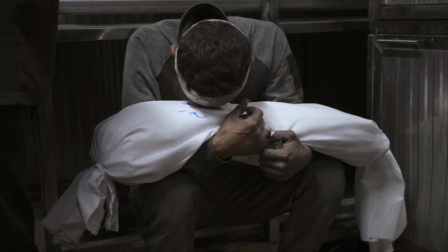 Un hombre palestino, junto al cuerpo de su hijo, muerto por los ataques del ejército israelí.
