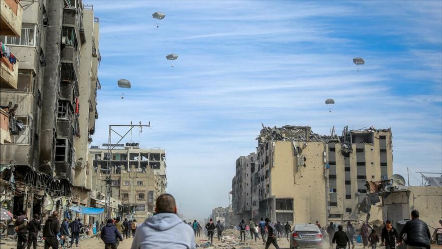 La gente observa el lanzamiento de ayuda sobre Gaza.
