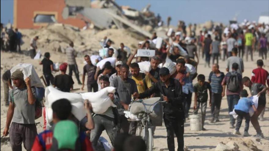 Palestinos transportan los suministros limitados de alimentos que han recibido en el cruce de Zikim, en la ciudad de Gaza, 2 de agosto de 2025. (Foto: Anadolu)