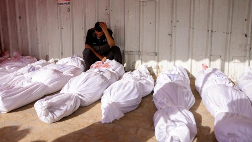 Hombre palestino reacciona mientras llora entre los cadáveres de las víctimas de los ataques israelíes en Jabalia, en el Hospital Indonesio de Beit Lahia, en el norte de la Franja de Gaza, 14 de mayo de 2025. (Foto de AFP) 