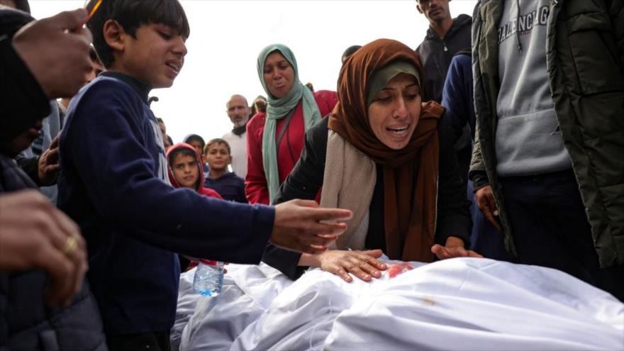Una mujer y un niño palestinos lloran el cuerpo de un familiar muerto en un ataque israelí, en el patio del hospital indonesio de Beit Lahia, 22 de marzo de 2025. 