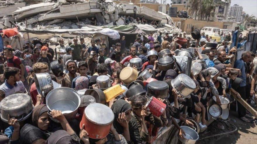 Palestinos hacen fila para recibir ayuda humanitaria en la asediada Franja de Gaza.