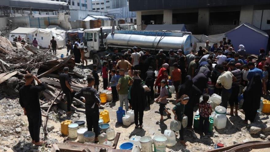 Los palestinos en cola para llenar sus recipientes con agua potable en Gaza.