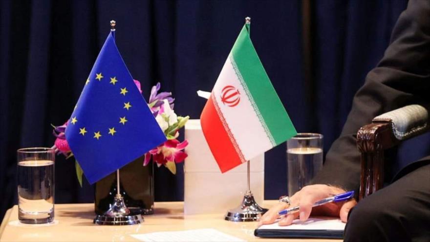 Una bandera de Irán (dcha.) y de la Unión Europea (UE) colocadas sobre la mesa.