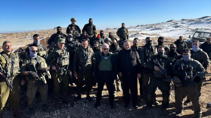 El premier israelí, Benjamín Netanyahu (C), el ministro de asuntos militares, Israel Katz, y otras tropas y funcionarios en la cima del Monte Hermón, en Siria, 17 de diciembre de 2024.