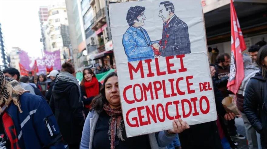 Una mujer argentina sostiene una pancarta que representa al presidente Milei estrechando la mano de Netanyahu, durante las protestas en Buenos Aires, 9 de agosto de 2025. (Foto: Reuters)