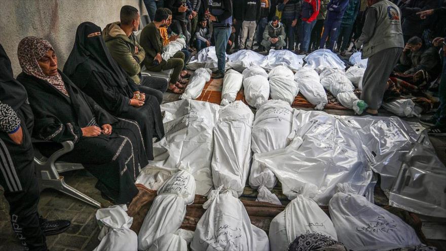 Palestinos esperan recibir los cuerpos de sus familiares asesinados en un ataque aéreo israelí en el Hospital Al-Najjar, al sur de la Franja de Gaza.