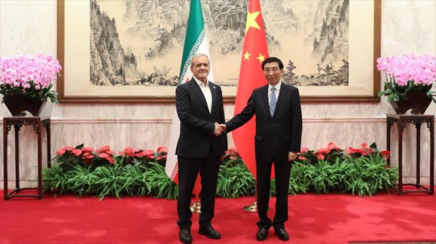 El presidente iraní, Masud Pezeshkian(izd.), y el miembro permanente del Partido Comunista Chino, Huang Hu, reunidos en Pekín, China, 3 de septiembre de 2025.