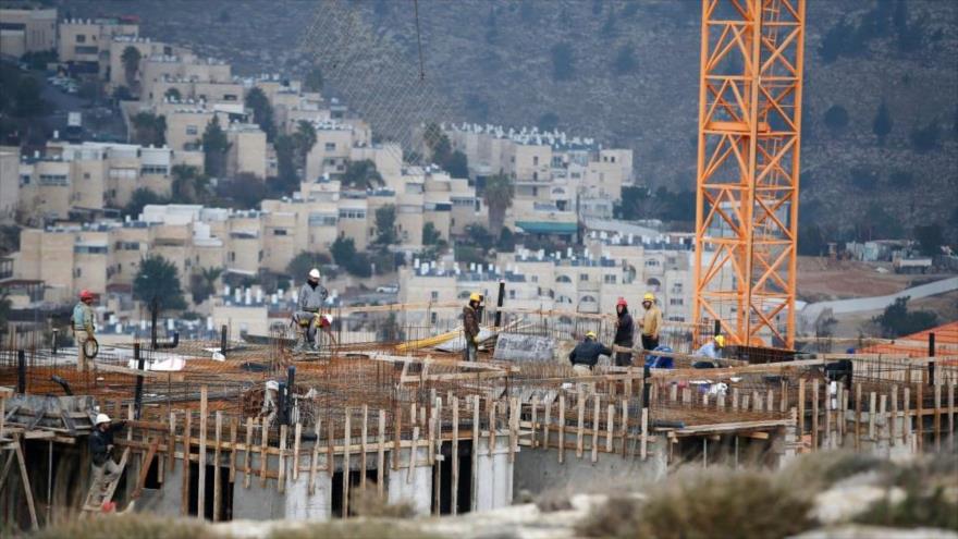 Obreros de la construcción trabajan en una obra de nuevas viviendas en el asentamiento judío de Neve Yaakov, en la zona norte de Jerusalén Este. (Foto: AFP) 