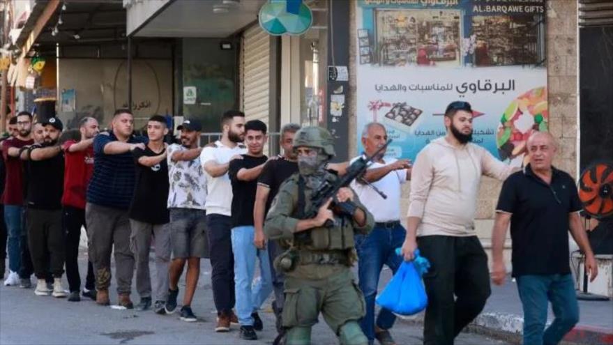 Soldados israelíes detienen a palestinos cerca de un puesto de control al oeste de Tulkarem, en Cisjordania ocupada. (FOTO: AFP)