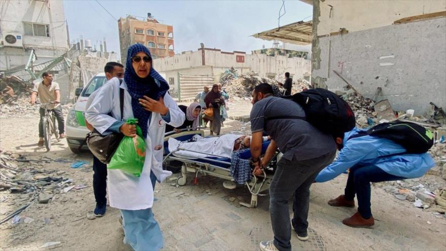 Personal médico trasladando a una persona herida en Gaza. 