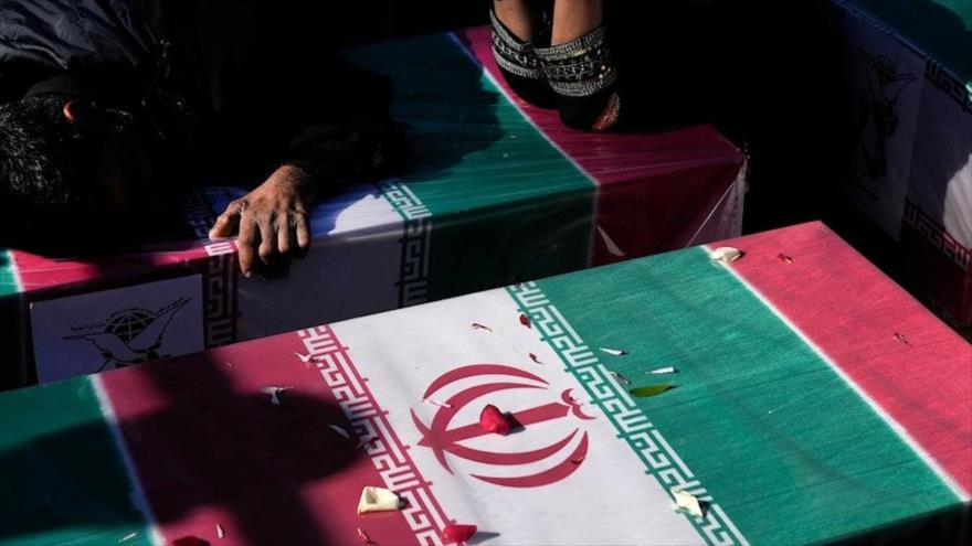 Los dolientes lloran ante el féretro cubierto con la bandera de su ser querido, asesinado en una explosión en la ciudad de Kerman, 5 de enero de 2024. (Foto: AP)