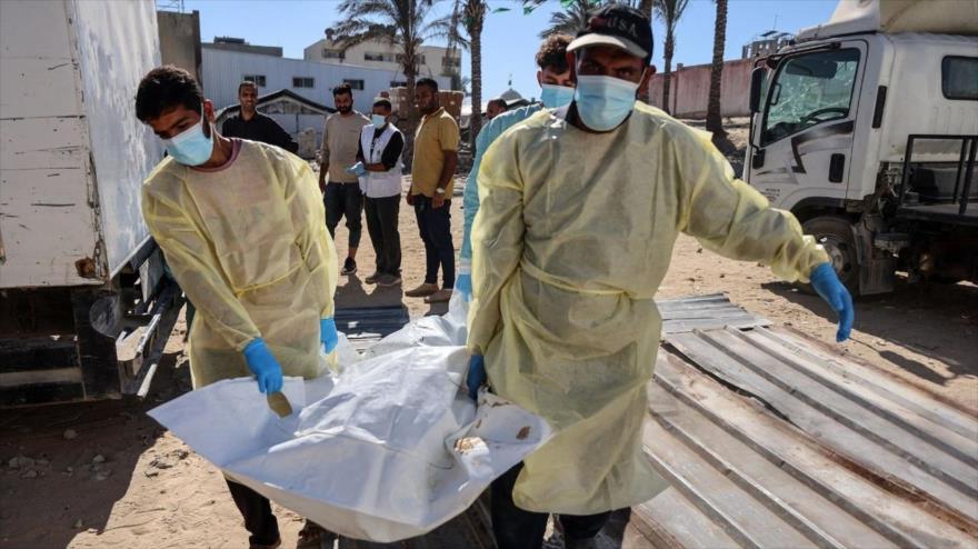 Trabajadores del hospital transportan los restos de un palestino liberado por Israel en virtud de un alto el fuego en Gaza, a la morgue del hospital Nasser en Jan Yunis, 18 de octubre de 2025.(Foto: AFP)
