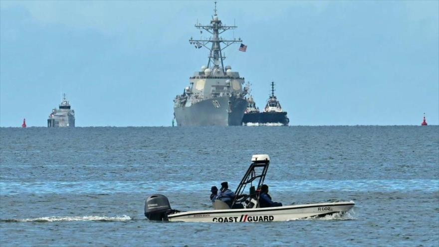 Una lancha rápida de la Guardia Costera de Trinidad y Tobago patrulla mientras el buque de guerra USS Gravely es visto desde Puerto España,26 de octubre de 2025.