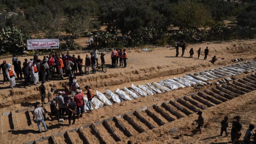 Cuerpos no identificados de palestinos asesinados por Israel son enterrados en una fosa común en Deir al-Balah, en el centro de Gaza, 27 de octubre de 2025.