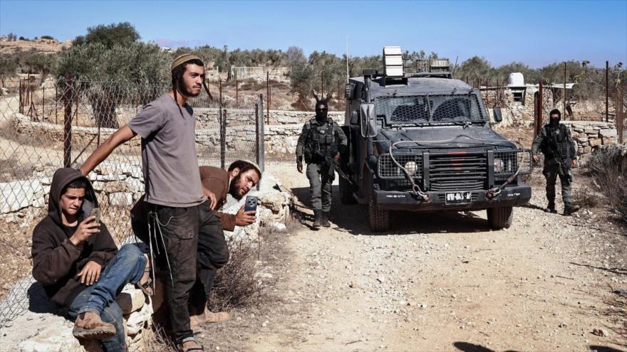 Guardias fronterizos y colonos israelíes cerca del pueblo palestino de Silwad, al noreste de Ramalá, en la Cisjordania ocupada, 29 de octubre de 2025. (Foto: AFP)
