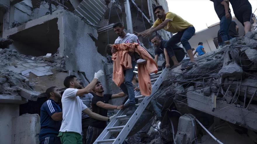 Palestinos rescatan a una niña de los escombros de un edificio residencial destruido luego de un ataque aéreo israelí, 10 de octubre de 2023. (Foto: AP)