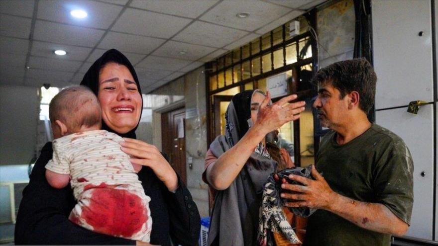 Una mujer lleva a su bebé herido tras los ataques israelíes contra la capital iraní, Teherán, 15 de junio de 2025. (Foto: Reuters)