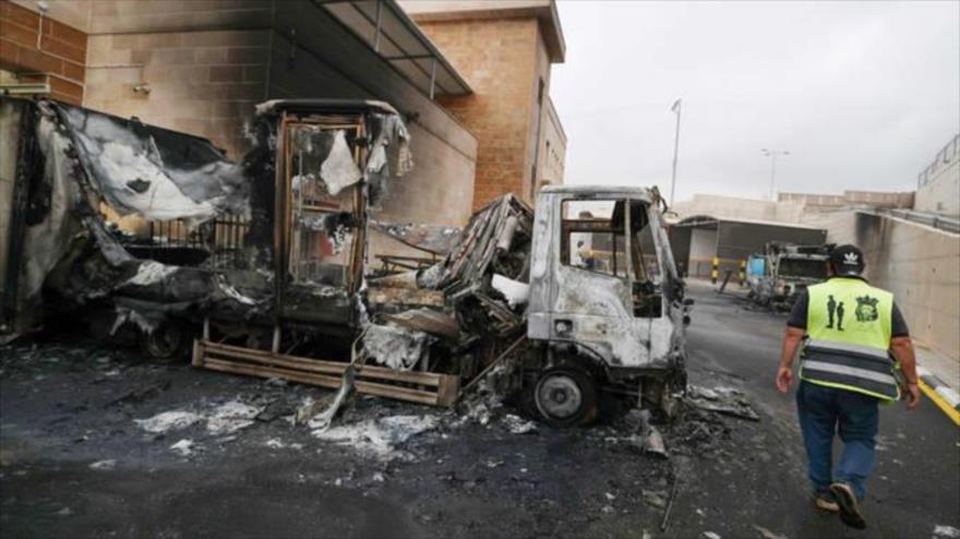 Un palestino inspecciona un camión quemado tras un ataque de colonos israelíes en la Cisjordania ocupada, 11 de noviembre de 2025. (Foto: AFP)
