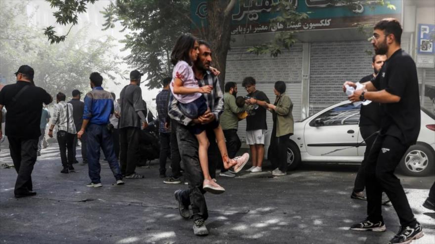 Un hombre carga a una niña herida tras una explosión en el centro de Teherán durante un ataque israelí contra Irán, 15 de junio de 2025. (Foto: AP)