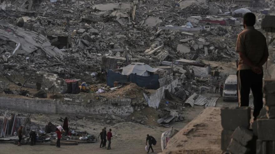 Palestinos caminan entre la destrucción causada por la ofensiva aérea y terrestre israelí en el barrio de Sheikh Radwan en la ciudad de Gaza,11 de noviembre de 2025. (Foto: AP)