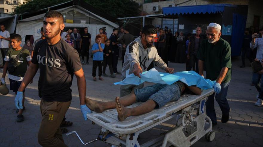 Palestinos trasladan en una camilla el cuerpo de un hombre asesinado en bombardeos israelíes en Deir al-Balah, 22 de noviembre de 2025. (Foto: AP)