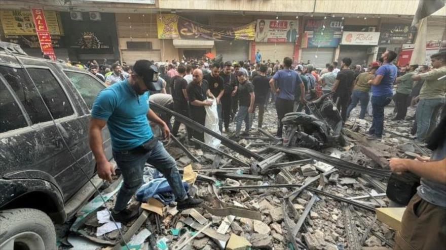 La gente observa los escombros tras un ataque militar israelí contra un edificio residencial en el barrio de Haret Hreik, en los suburbios del sur de Beirut, 23 de noviembre de 2025. (Foto: AFP)