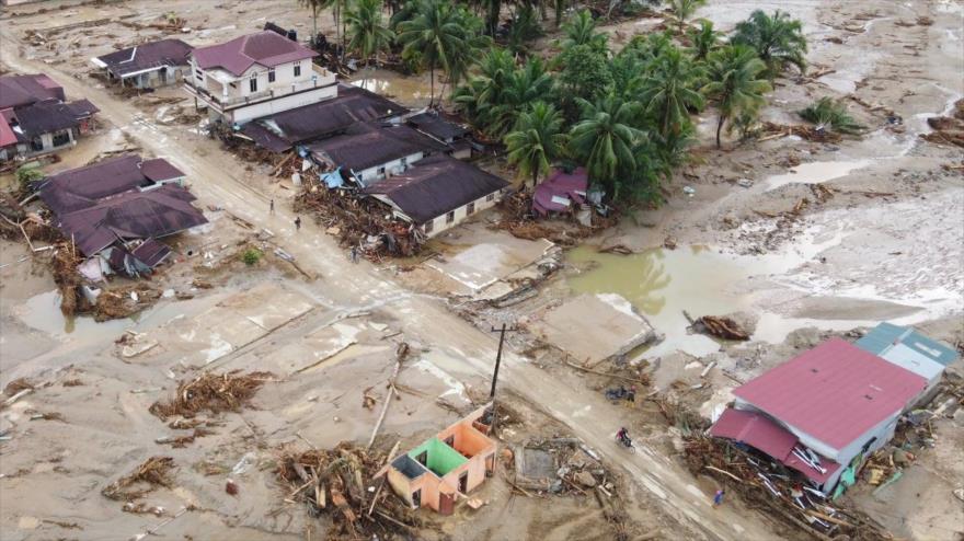 Gente camina por un camino fangoso en un pueblo inundado de Batang Toru, Indonesia, 2 de diciembre de 2025. (Foto: AP)