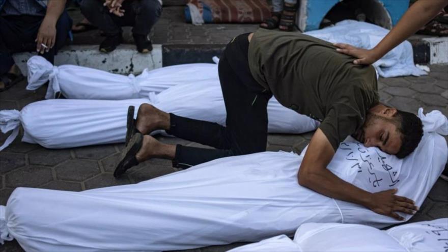 Un joven palestino abraza el cuerdo de su querido asesinado por ataques israelíes en Gaza. 