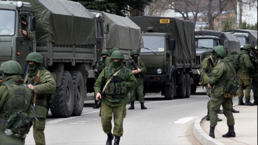 Militares armados esperan cerca de vehículos del ejército ruso frente a un puesto fronterizo ucraniano en la ciudad de Balaclava, Crimea. (Foto: Reuters)