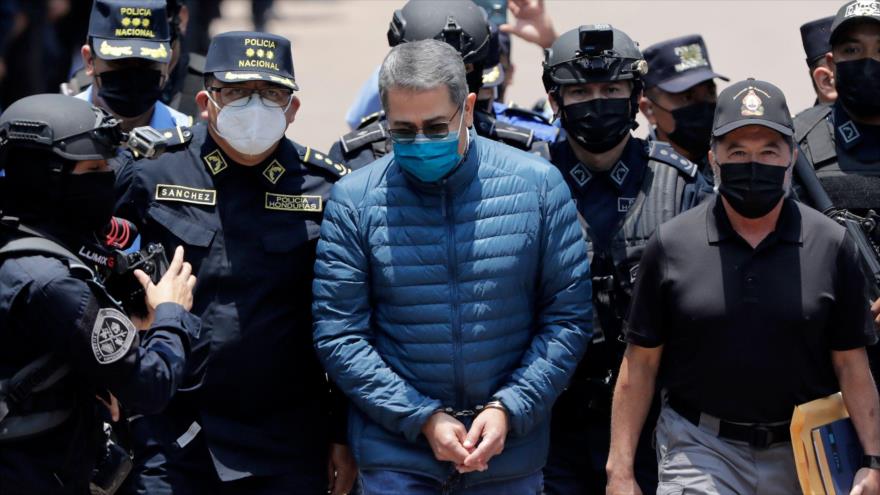 El expresidente hondureño Juan Orlando Hernández es conducido esposado a un avión para su extradición a EE.UU., en una base aérea de Tegucigalpa, Honduras, 21 de abril de 2022.
