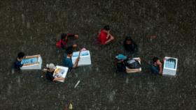 Residentes de Bangkok sortean aguas hasta la cintura por inundaciones